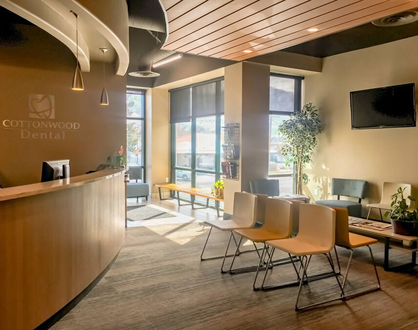 Cottonwood Dental reception area featuring modern waiting chairs, front desk, and large windows in Salt Lake City.