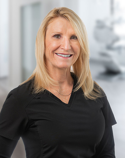 Shelli, a dental team member at the Salt Lake City practice, smiles warmly at the camera.