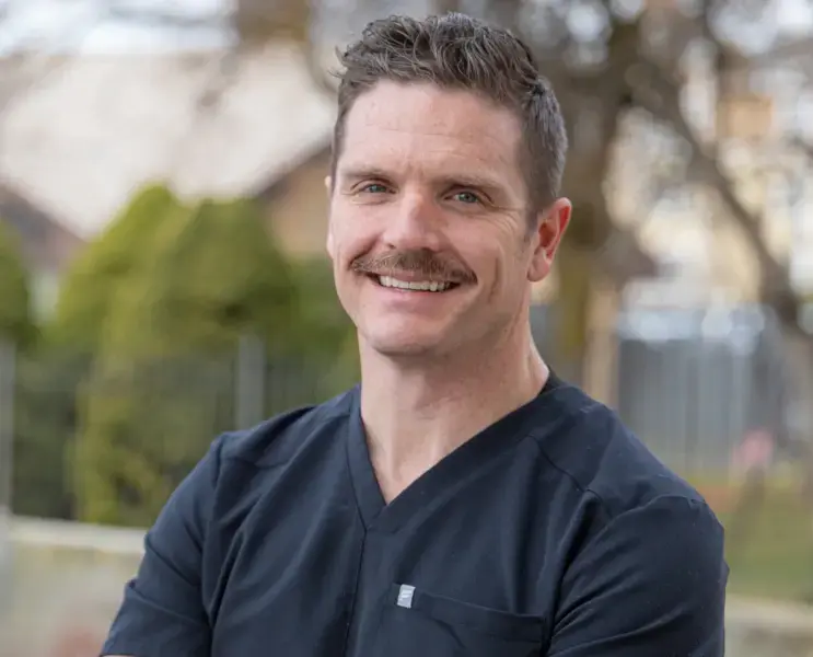 Dr. Cody Boseman, dentist at Highland Drive dental practice in Salt Lake City, smiling outdoors.