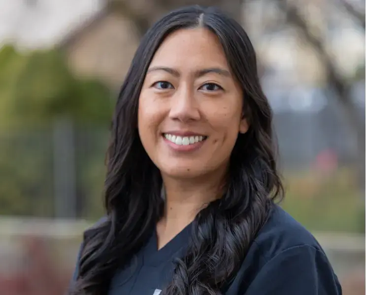 Dr. Nguyen, dentist at Highland Drive dental practice in Salt Lake City, smiling outdoors.