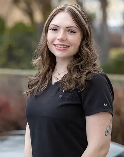 Kyra, dental team member at Highland Drive practice in Salt Lake City, smiling outdoors.