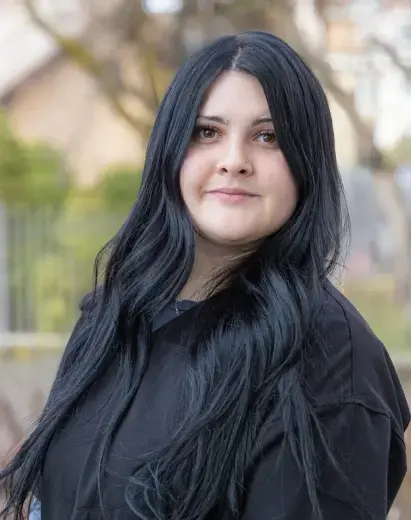 Professional headshot of a woman with long dark hair smiling at the dental practice in Salt Lake City.